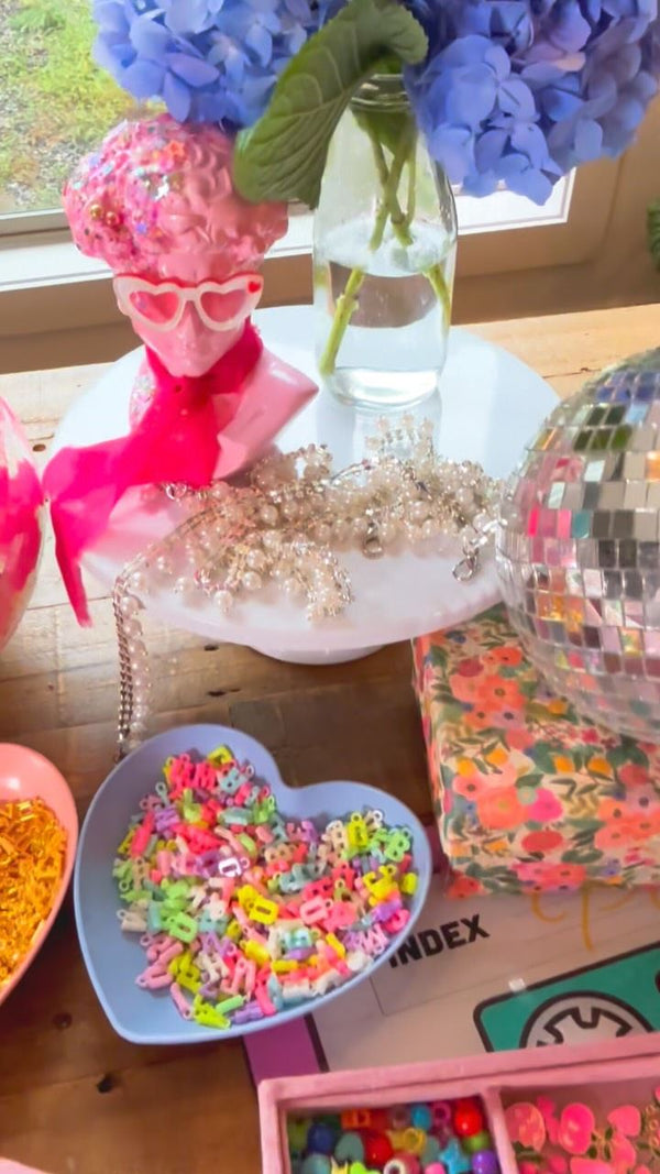 Birthday party favors or party activity ideas for tweens or kids parties, with a charm bar kit to decorate shoes, make DIY keychains, decorate your own journal, or host a charm bracelet party.