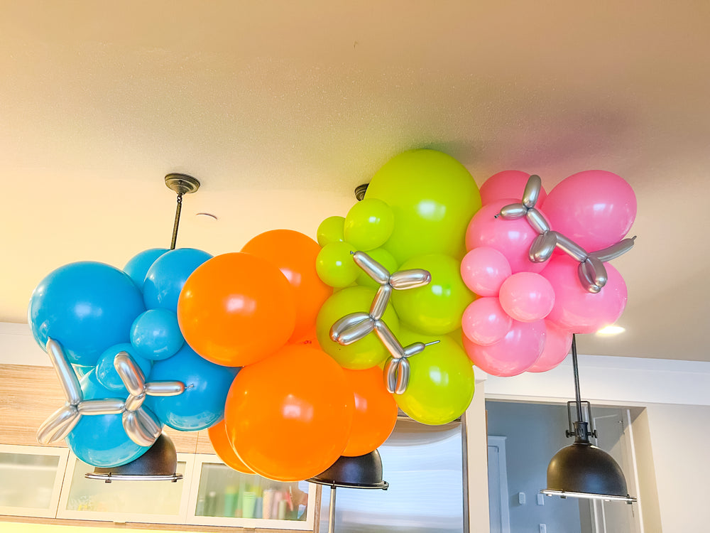 DIY balloon garland kit with blue, orange, green, and pink balloons and silver balloon animal decorations.