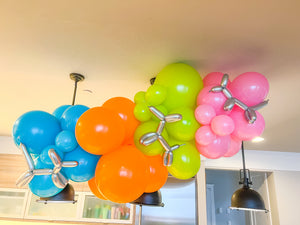 DIY balloon garland kit with blue, orange, green, and pink balloons and silver balloon animal decorations.