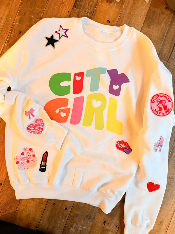 A custom decorated sweatshirt with patches and decorations for a sweatshirt patch party activity or party favor for a birthday party for tweens or kids.