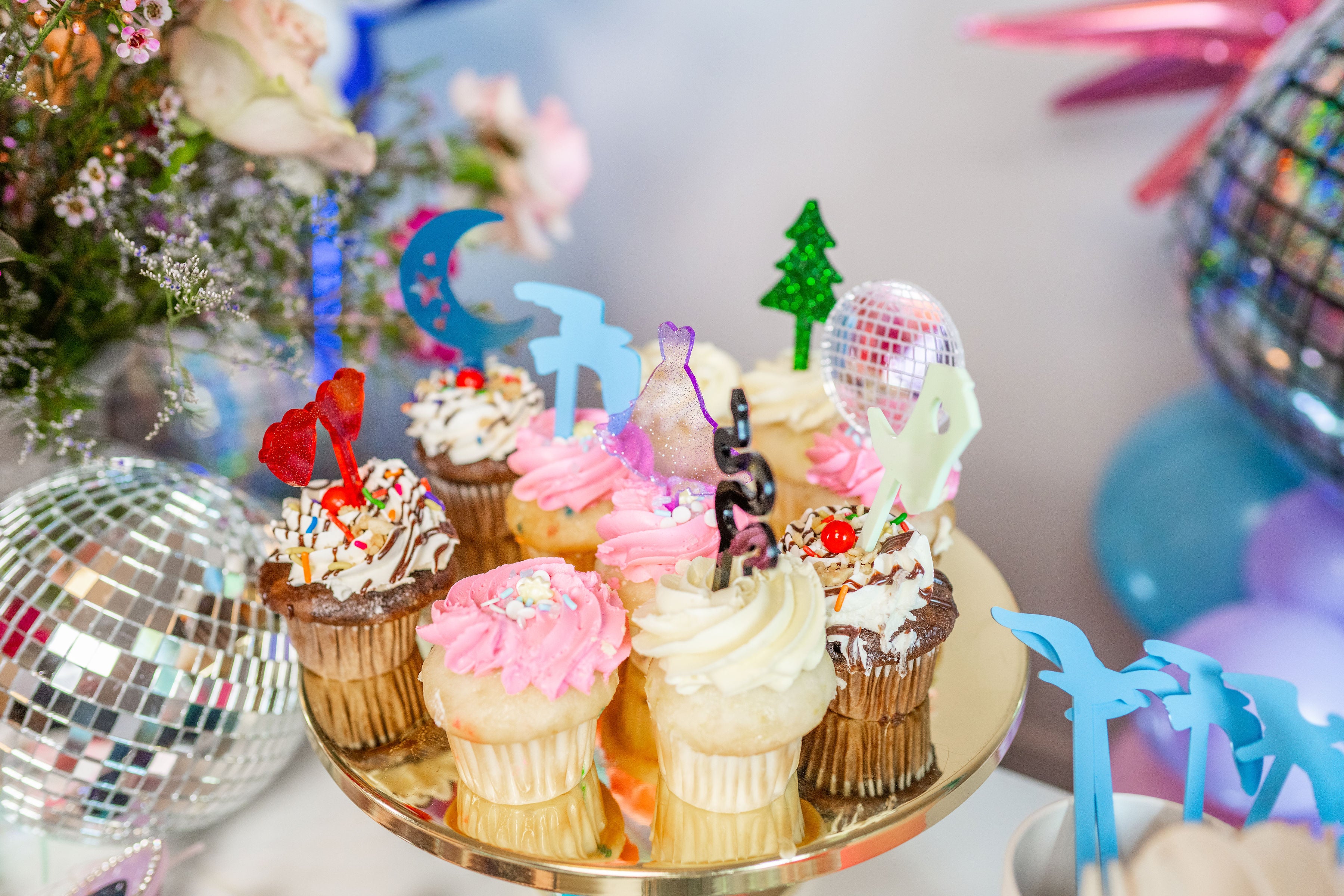 Taylor Swift birthday cupcakes with Eras tour cake toppers for a cute tween and teen Swiftie birthday party theme.