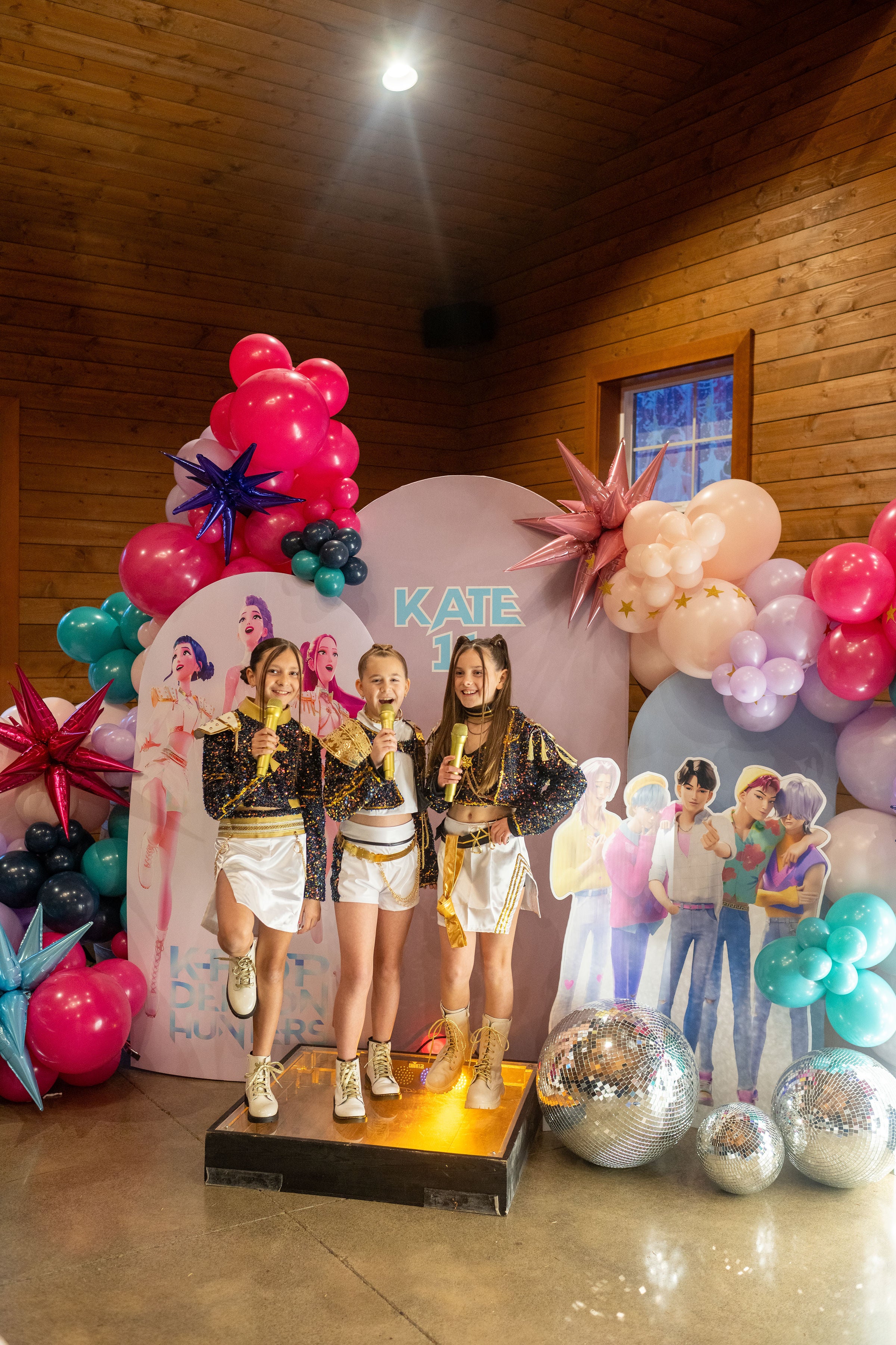 Kpop demon hunters party decor for tweens, featuring a Kpop demon hunters photo backdrop and balloon arch.
