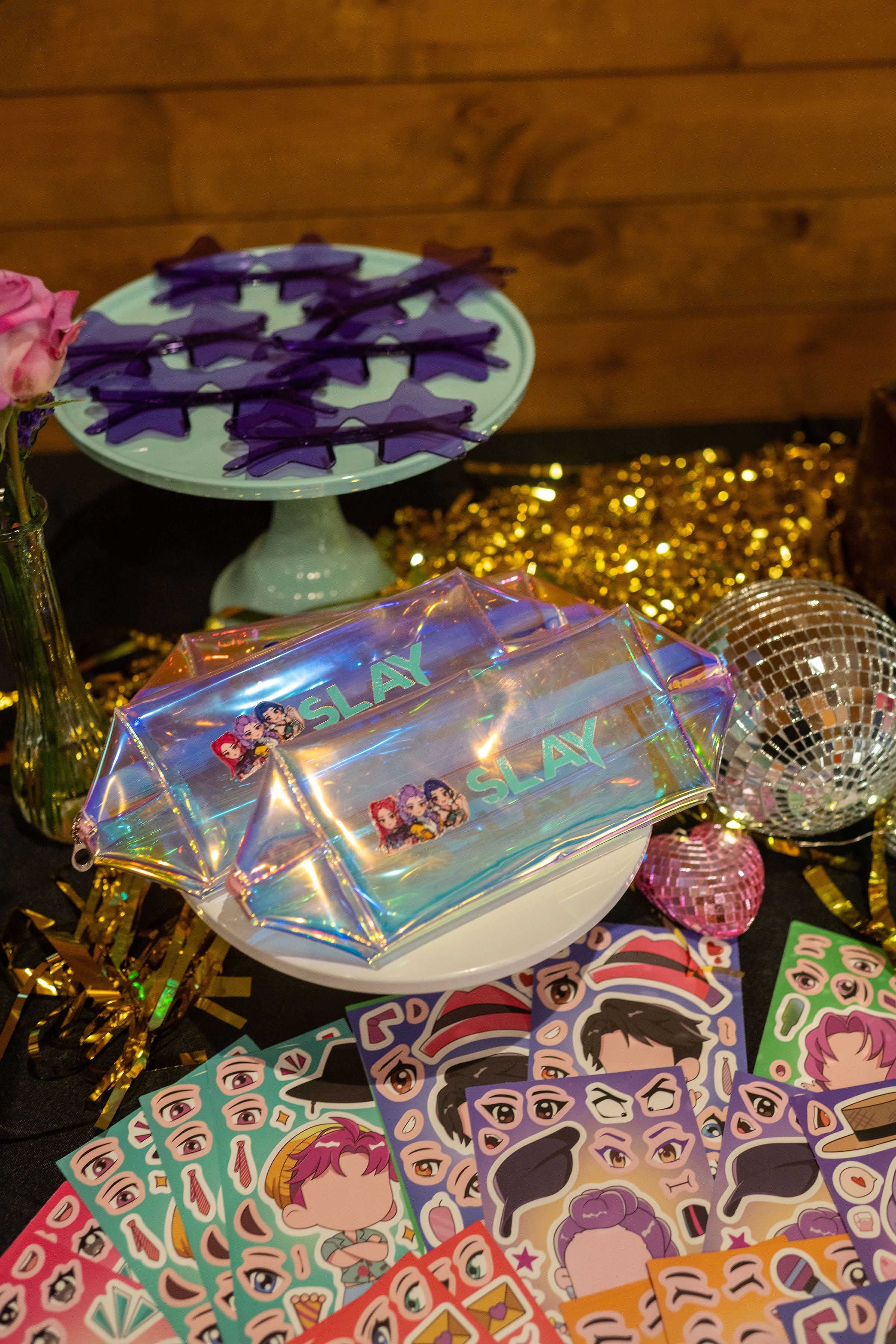 Kpop demon hunters party favors for a tween party idea, including huntrx rumi bags, purple star sunglasses, and sticker party activities.