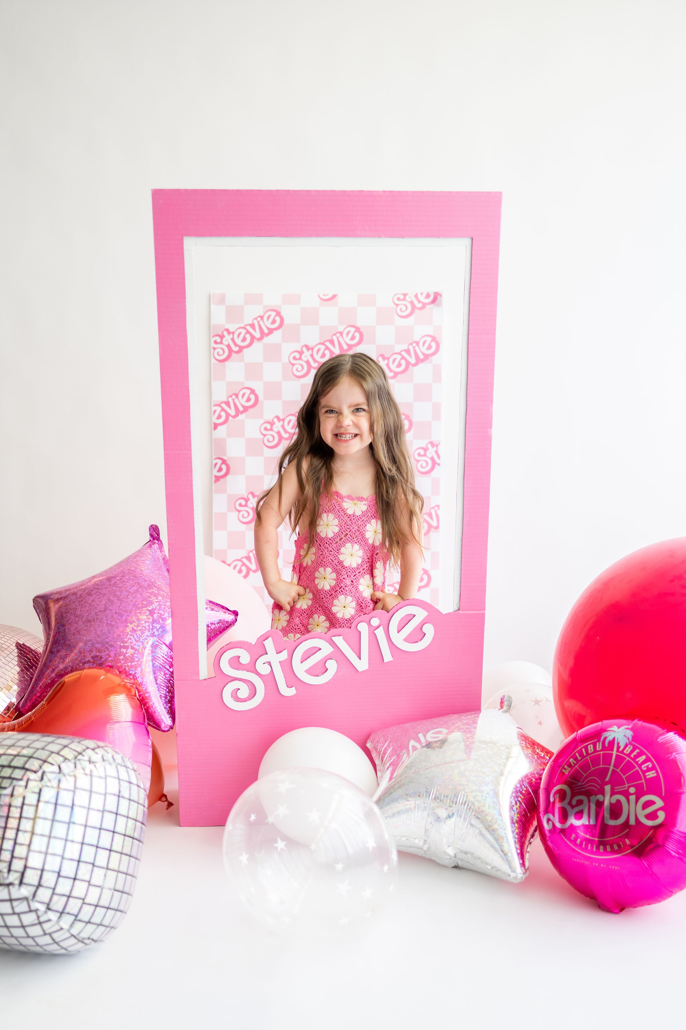 Toddler birthday party idea for a girls' Barbie party or a pink party theme inspired by Malibu Barbie, featuring a Barbie photo backdrop.