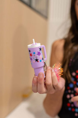 A mini purple keychain shaped like a stanley tumbler, used as a tween or teen birthday party favor idea.