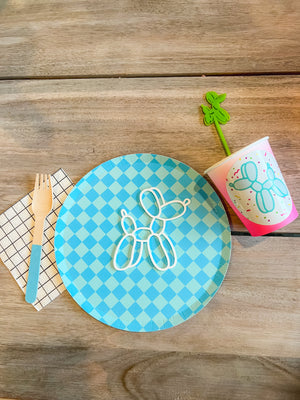 Tableware for a fun, bright balloon animal themed birthday party, including a blue checked paper plate and a checkered napkin.