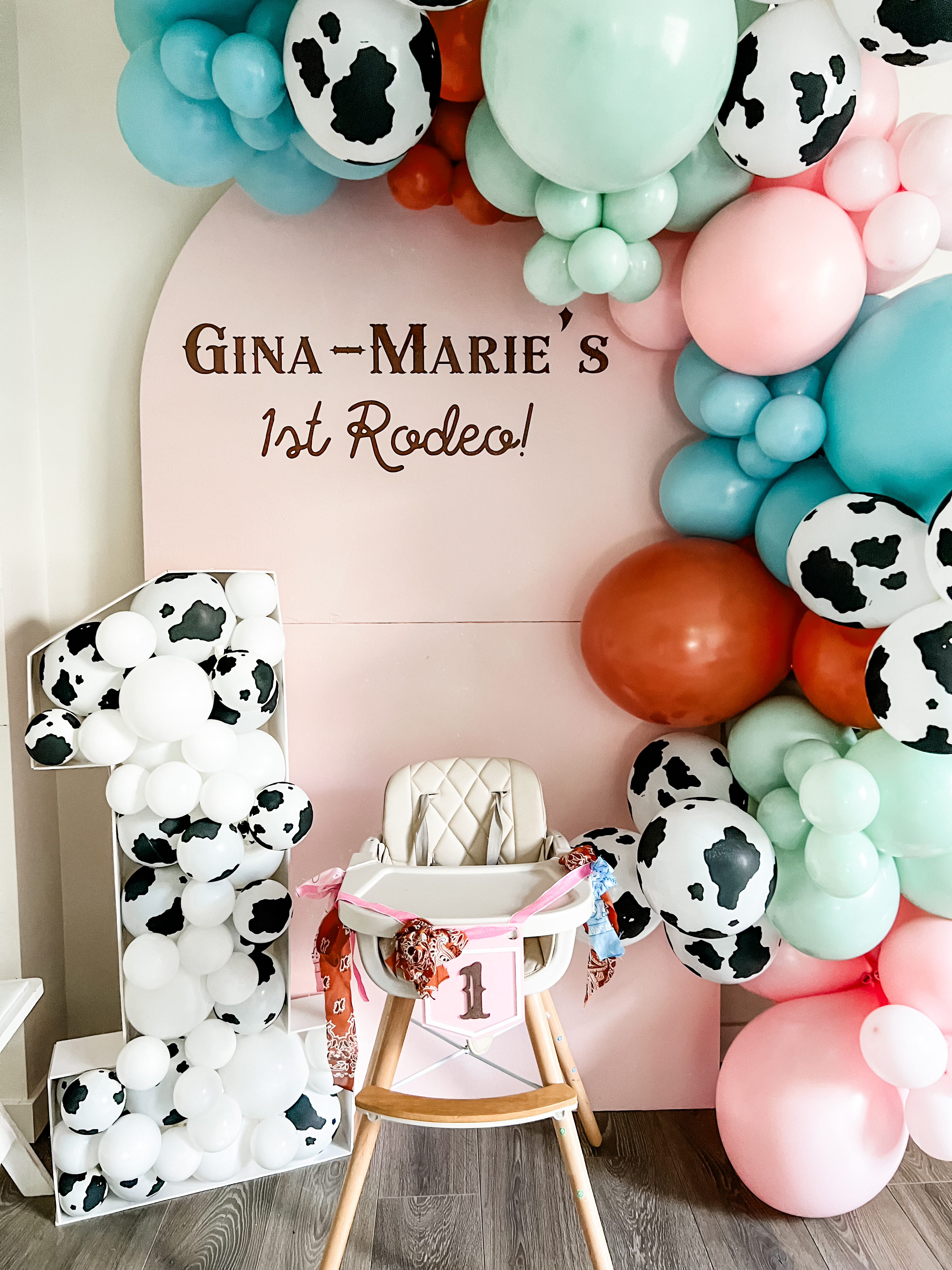 First birthday party inspiration for a rodeo birthday party with a cowboy balloon garland backdrop for a cake smash for a one-year-old.