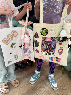 A decorate your own book bag patch bar kit for a Kpop Demon Hunters birthday party with Huntrix patches and halloween patches.