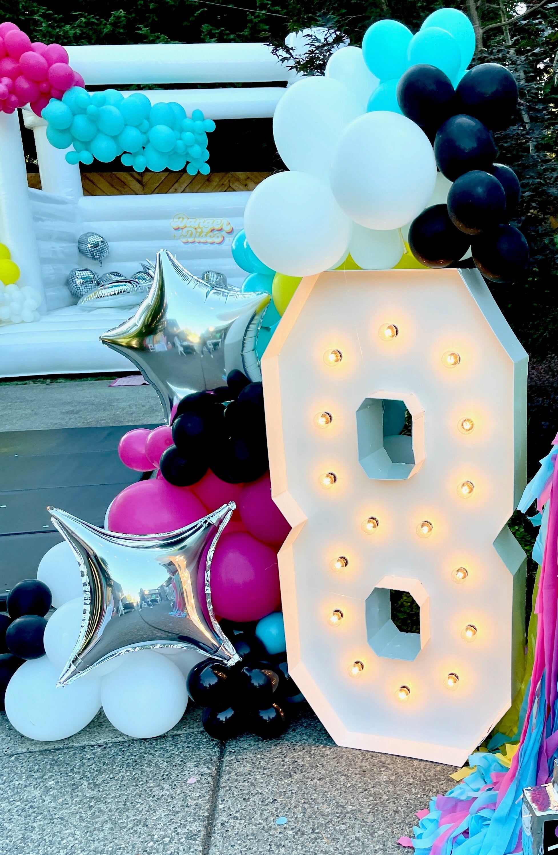 Decor inspiration for an 80s birthday party theme for kids, adults, or teens, with a balloon garland DIY kit and marquee letters.