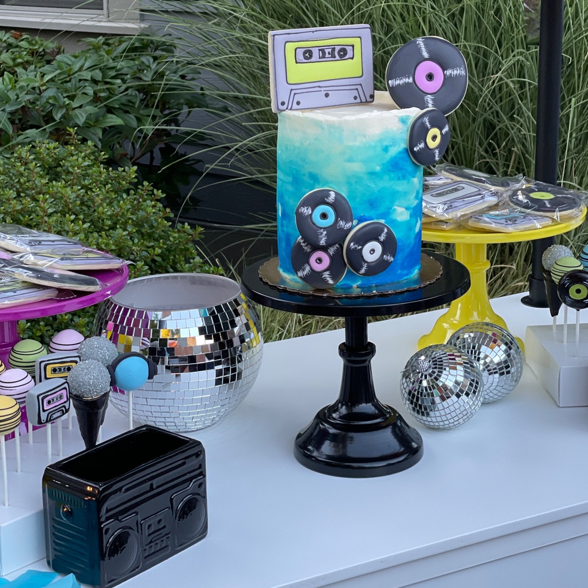 A cake table inspiration photo featuring party details from a disco theme party music decor kit for adults, kids, or teens.