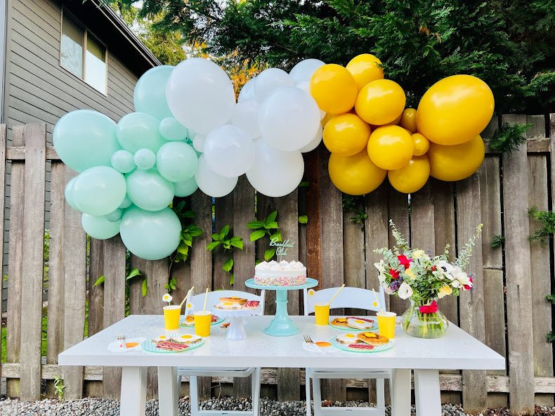 A purple and multicolor metallic star custom balloon garland kit with a custom spill ur guts balloon is used as a decoration idea for an Olivia Rodrigo birthday party featuring cake table decoration ideas.
