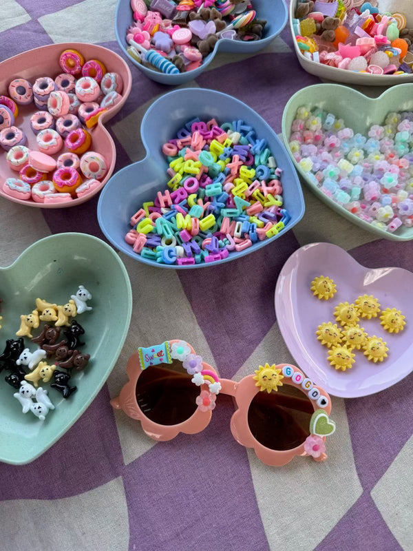 A charm bar party activity or party favor idea with a decorate your own sunglasses kit for a tween or kids with customizable charms for a girls birthday party.