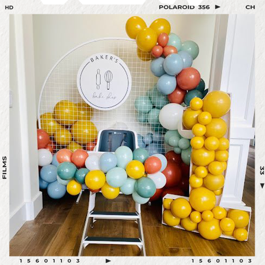 Gender-neutral first birthday party inspiration with a smash cake photo backdrop made out of a diy balloon garland kit and balloon arch ideas.