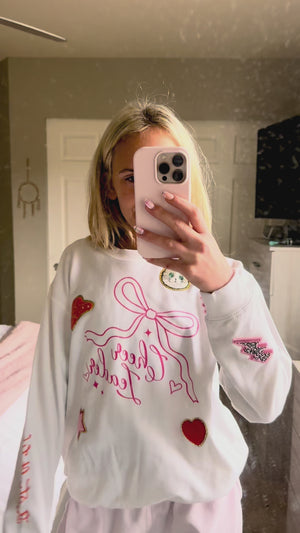 A young girl wearing a sweatshirt she decorated at a birthday party patch party activity.