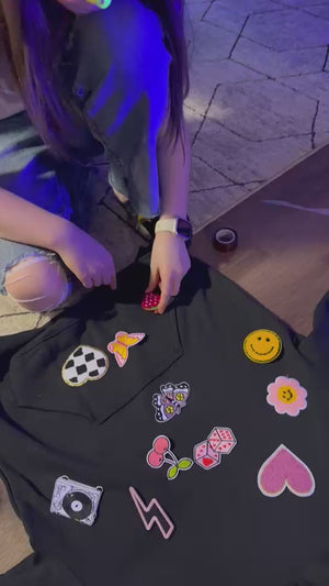 An Olivia Rodrigo themed party activity idea for tweens or kids featuring a patch party kit to decorate your own sweatshirts with customizable zip-up hoodies.