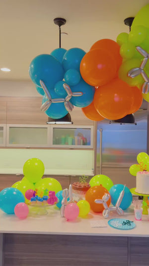 Blue, orange, green, and silver diy balloon garland kit with metallic balloon animals and tablescape ideas for a tween or teen party.