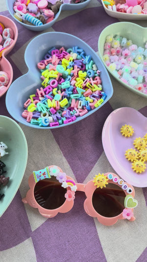 A charm bar party activity or party favor idea with a decorate your own sunglasses kit for a tween or kids with customizable charms for a girls birthday party.