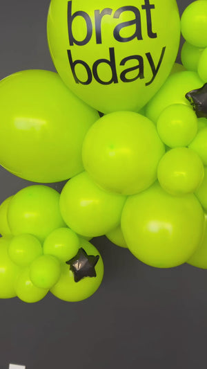 Brat party decorations with a Charlie XCX grab and go balloon garland kit in lime green with black foil star balloons.